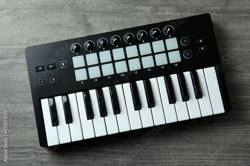 Midi keyboard on gray textured background, top view