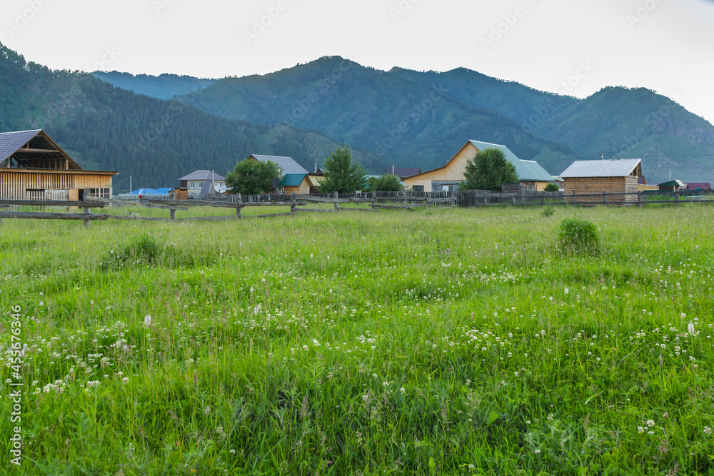 Field and houses in the village of Chemal in the Altai mountains Field and houses in the village of Chemal in the Altai mountains