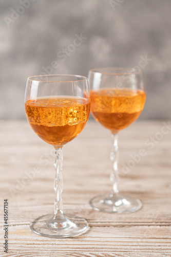 Homemade Aperol spritz. Orange sparkling cocktail in a glass on a wooden table. Vertical image