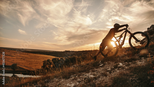 Fotografía Cyclist with mountain bike at sunset