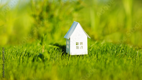  paper house against the background of green grass. climate change. ECO friendly house. 