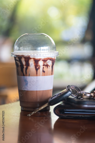 Iced mocha coffee put on the table next to the wallet, car keys and mobile phone