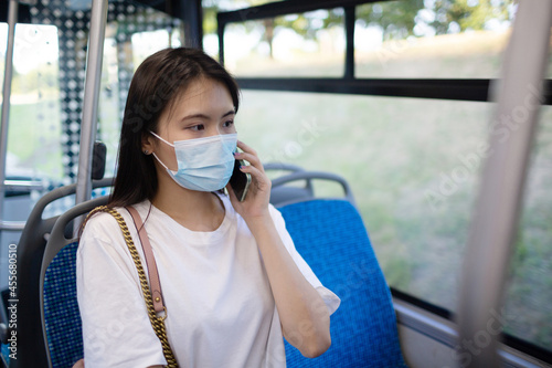 Asian Woman take a ride sit in public transport bus or tram