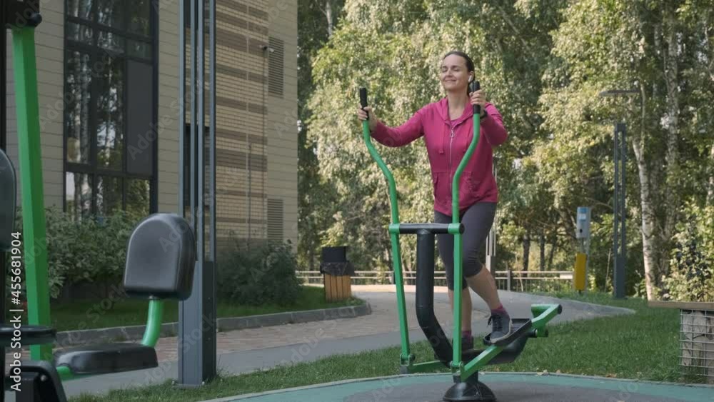 Young Woman Doing Work Out in an Outdoors Gym. Slow Motion. Fitness, Sport, Exercising and Lifestyle Concept Young Woman Doing Work Out in an Outdoors Gym. Slow Motion. Fitness, Sport, Exercising and Lifestyle Concept
