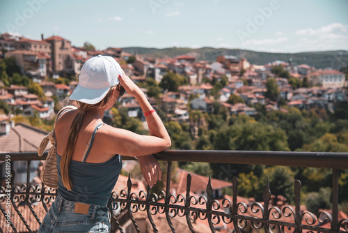 A teenage girl stands on the observation deck above the city.