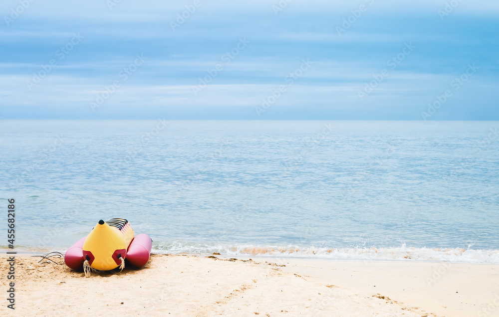 Banana boat for tourists on the sandy beach. Fun activities on the water with inflatable boats. Sea trip. Summer vacation. Banana boat for tourists on the sandy beach. Fun activities on the water with inflatable boats. Sea trip. Summer vacation.