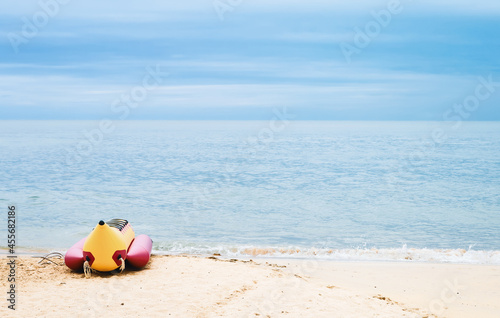 Banana boat for tourists on the sandy beach. Fun activities on the water with inflatable boats. Sea trip. Summer vacation.