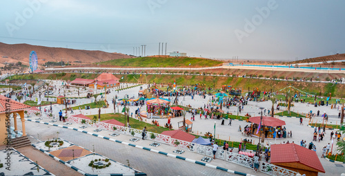 cityscape for an amusement park and children games with nice ferris wheel at night with bleu sky on hodna bey magra m'sila in algeria photo