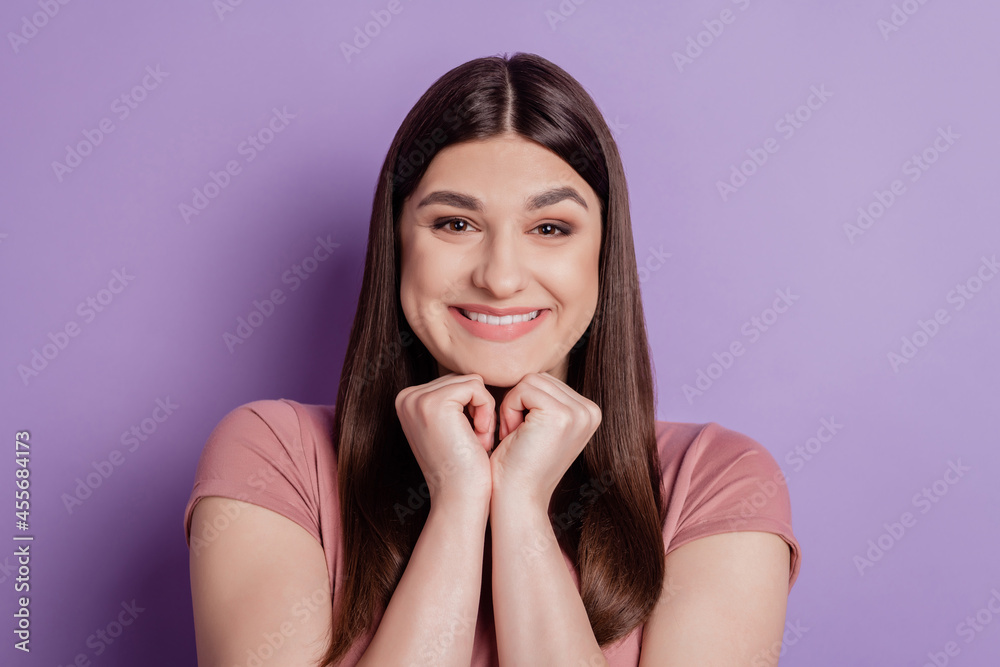 Close up photo of nice attractive girl toothy smile wear casual t-shirt hands touch chin isolated over violet color background Close up photo of nice attractive girl toothy smile wear casual t-shirt hands touch chin isolated over violet color background
