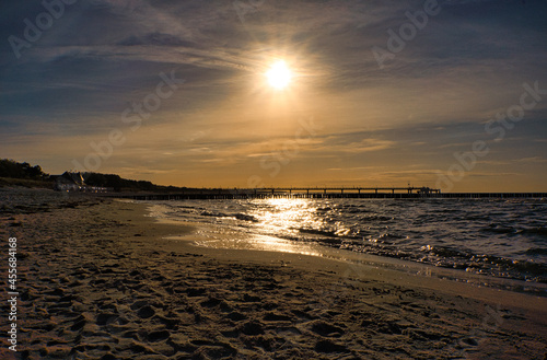 sunset in Zingst at the sea. red orange sun sets on the horizon. Seagulls circle in the sky