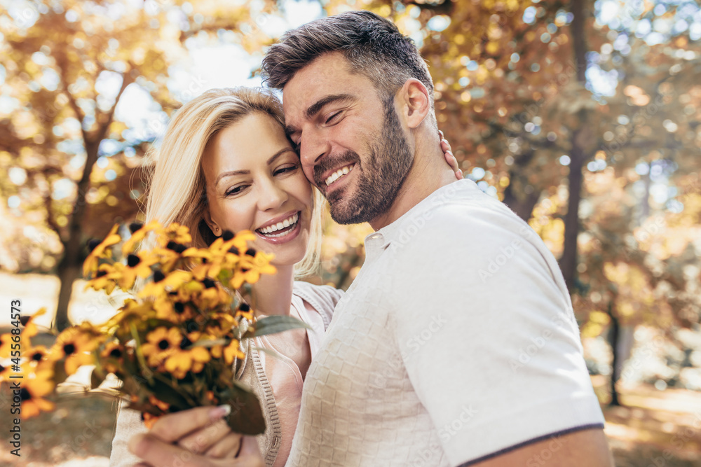 Loving young couple on a date with flowers in the park Loving young couple on a date with flowers in the park