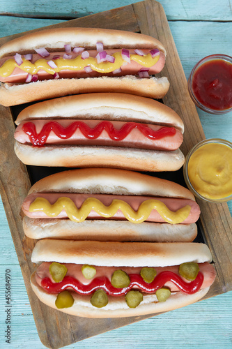 hot dogs with mustard and ketchup on wooden background © Diana Taliun
