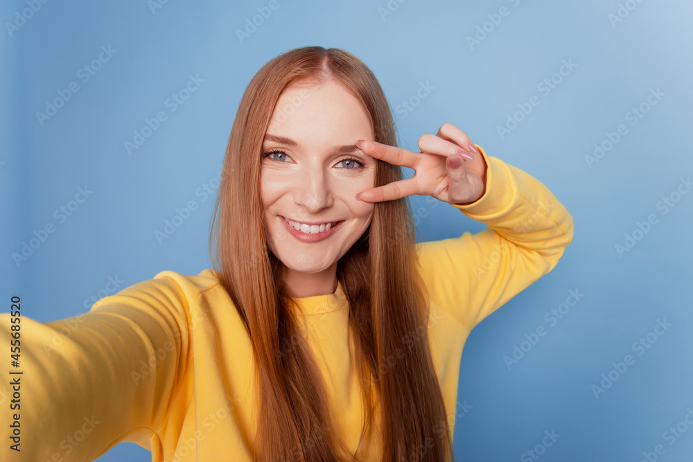 Portrait of charming reliable lady make selfie beaming smile show v-sign cover eye on blue background Portrait of charming reliable lady make selfie beaming smile show v-sign cover eye on blue background