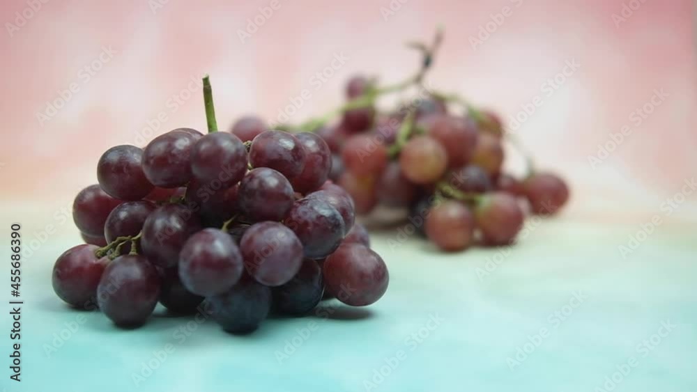 Man putting red seedless grapes on table Man putting red seedless grapes on table