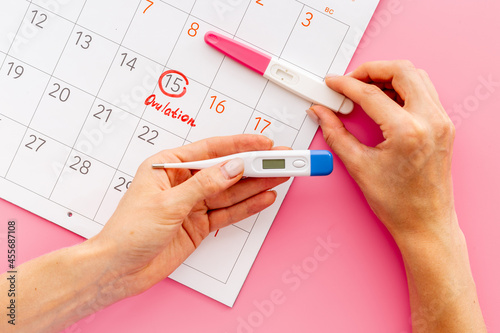 Billede på lærred Ovulation home test in female hand over calendar with red mark