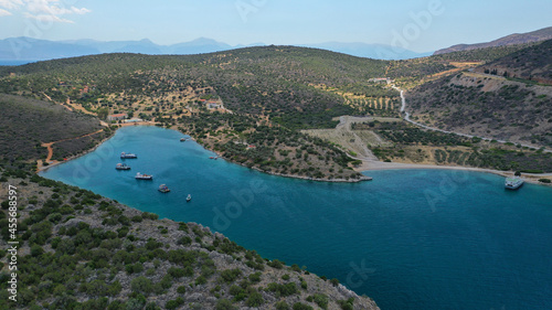 Aerial drone photo of large fish farming - breeding unit of sea bass and sea bream in huge round cages with latest technology automatic feeding system, calm deep sea of Anemokambi, Galaxidi, Greece