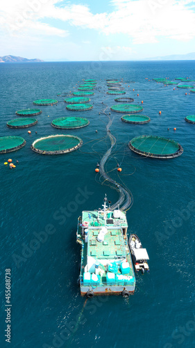 Aerial drone photo of latest technology auto feeding fish farming - breeding unit of sea bass and sea bream in huge round cages located in calm Mediterranean sea