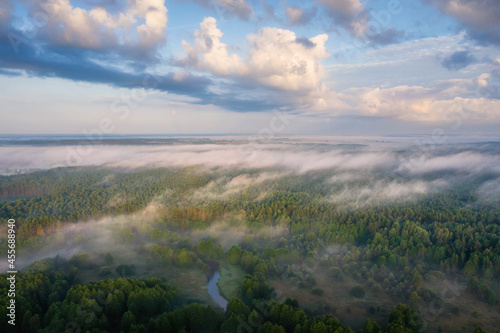 Obraz na płótnie Aerial view of scenery by misty woodland. Earler morning the first day of autumn. Cloudy sunrise above misty forest. w salonie