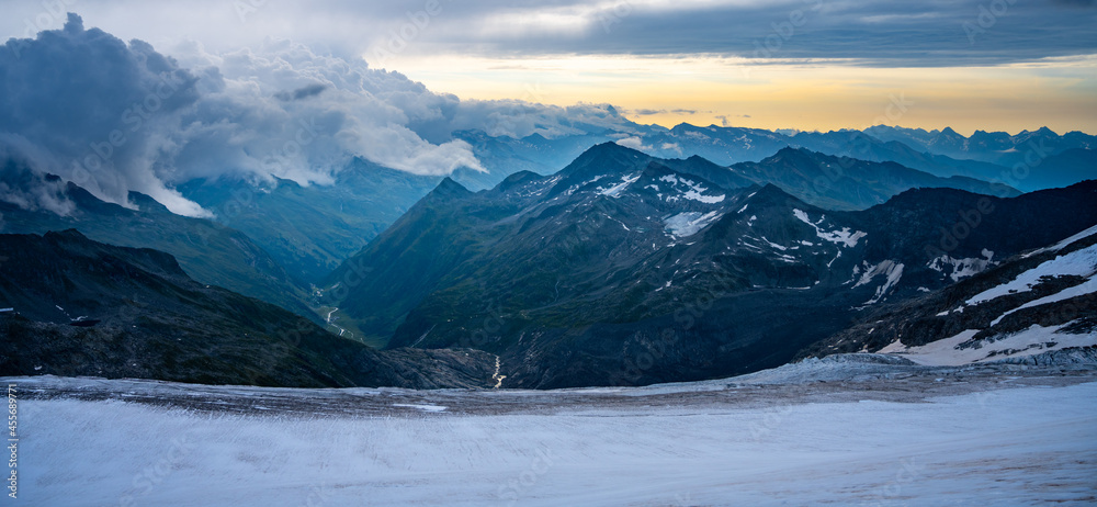 Rocky alpine mountains morning panorama. Cloudy sunrise on summer day. Grossglockner Mountain, Hohe Tauern National Park, Austrian Alps