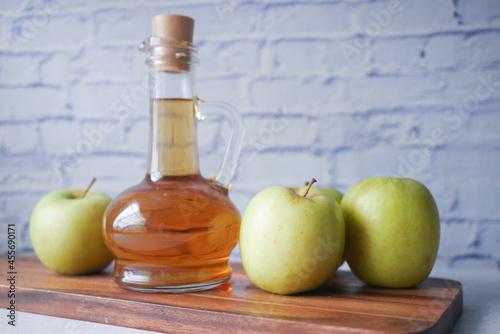 Fototapeta Naklejka Na Ścianę i Meble -  apple vinegar in glass bottle with fresh green apple on table 