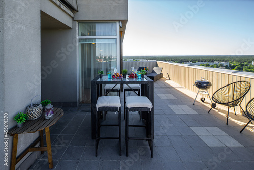 Sunbeds on outdoor terrace in luxury apartment. Table and chairs