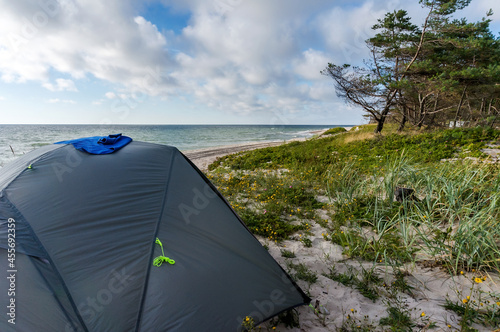 Gray camping tent on the sea. Camping on the beach. Recreation of nature with tents.