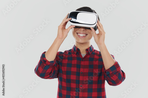 Smiling asian man using virtual reality glasses