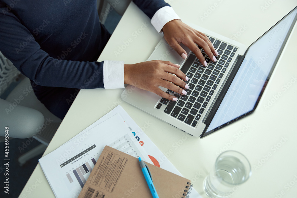 African businesswoman typing on laptop at desk African businesswoman typing on laptop at desk