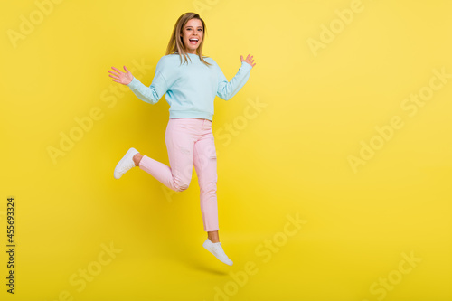 Full length body size view of pretty cheerful girl jumping walking having fun copy space isolated over bright yellow color background