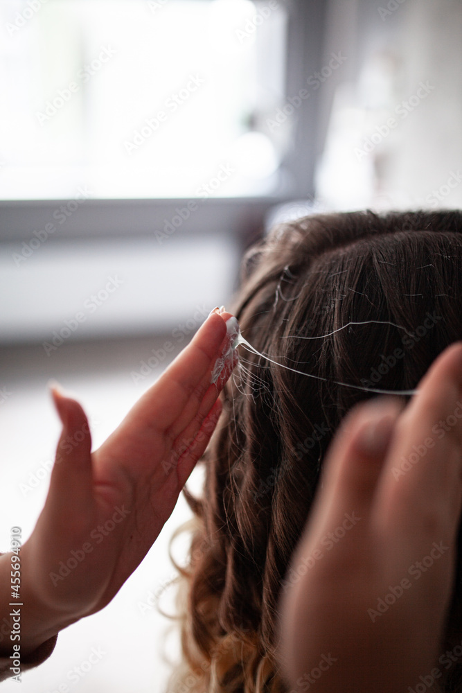 Fototapeta premium stylist hairdresser makes a hairstyle for a girl in his beauty salon, hollywood wave, beautiful hairstyle, hairdresser at work