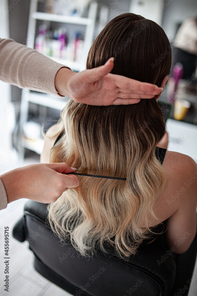 stylist hairdresser makes a hairstyle for a girl in his beauty salon, hollywood wave, beautiful hairstyle, hairdresser at work stylist hairdresser makes a hairstyle for a girl in his beauty salon, hollywood wave, beautiful hairstyle, hairdresser at work