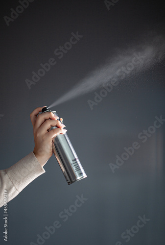hair stylist demonstrates hair products, hairspray sprinkles in the air, a hair stylist and his tools, a stylist's content shoot