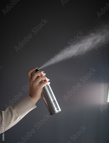 hair stylist demonstrates hair products, hairspray sprinkles in the air, a hair stylist and his tools, a stylist's content shoot