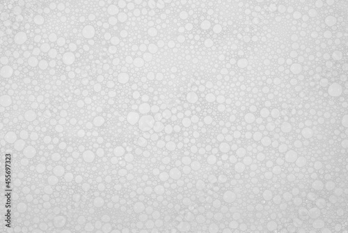 Texture of small soap bubbles on water background. foam