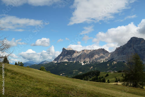 idyllic view of a mountain in the alps with a green meadow in the foreground and a high mountain