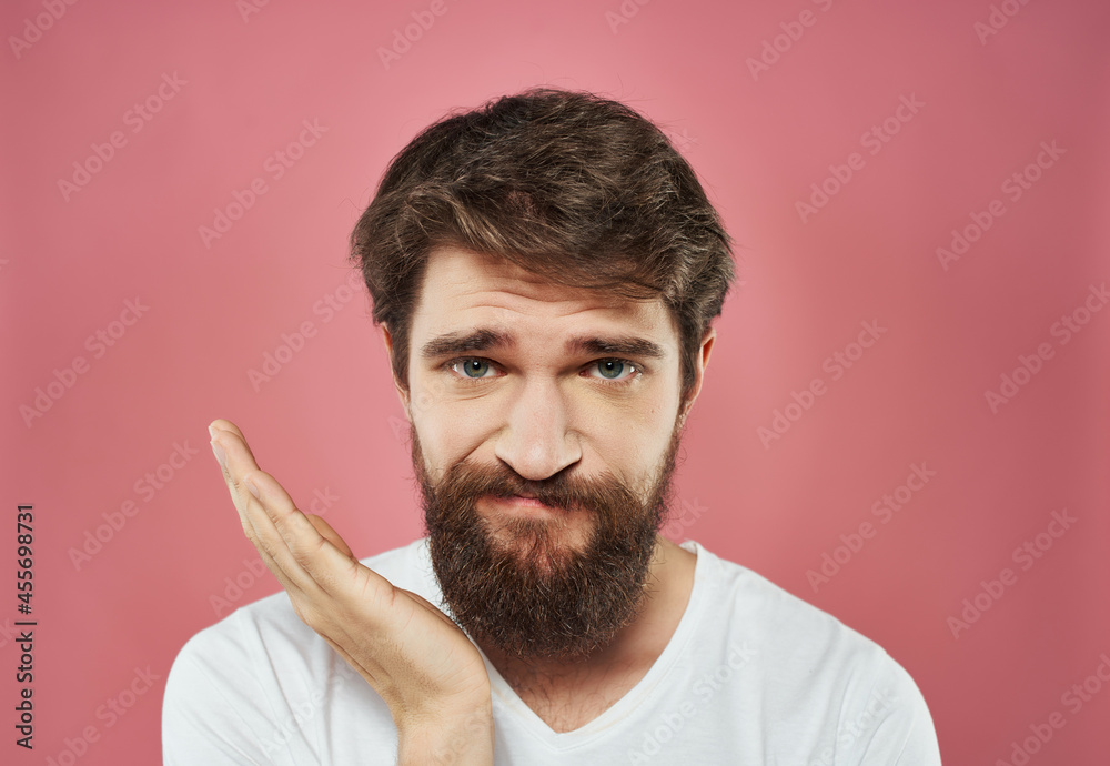 Man in a white t-shirt expressive look discontent close-up