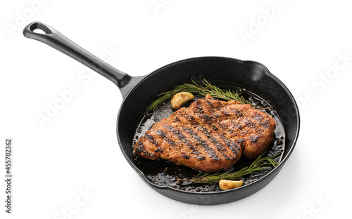 Delicious juicy pork steak with garlic and rosemary in a cast iron pan.