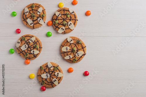 Halloween Cookies with ghosts, spiderweb on wooden table. Fall time, halloween concept.
