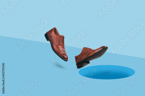 Billede på lærred Men's  brown leather shoes in motion falling into dark hole in a floor
