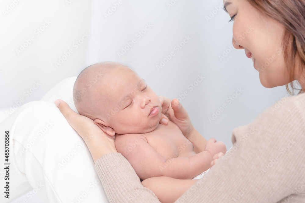 Close up beautiful young asian mother holding her newborn one month baby sleep on her arms. Healthcare and medical love asia woman lifestyle mother's day concept. Close up beautiful young asian mother holding her newborn one month baby sleep on her arms. Healthcare and medical love asia woman lifestyle mother's day concept.