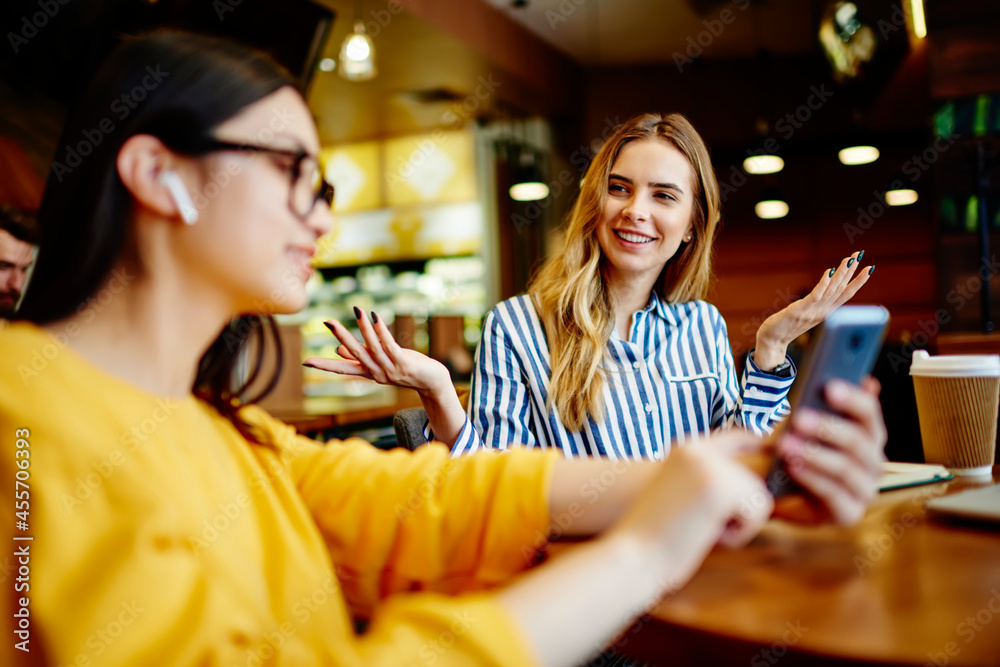 Young women talking about last news surfing smartphone Young women talking about last news surfing smartphone