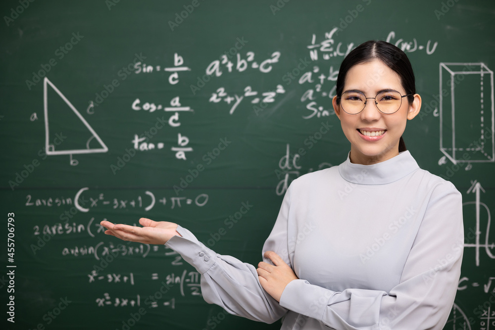 Young asian teacher woman open hand palm up and video conference with student looking camera. Female teacher training the mathematics in classroom blackboard from online course.