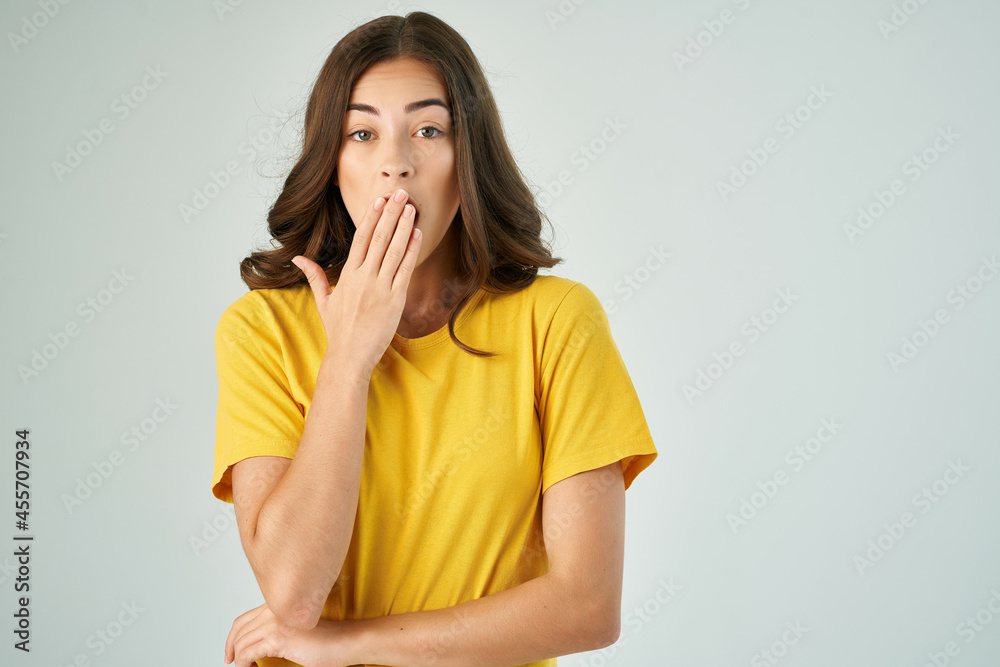 surprised woman in a yellow t-shirt studio emotions discontent