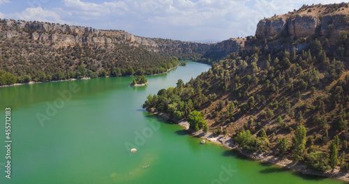 Canon summer landscape, panoramic, gorge with green water and an island 