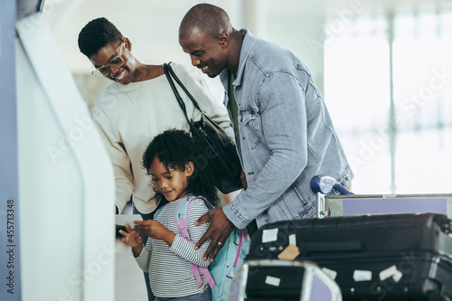 Young girl holding boarding pass print at airport