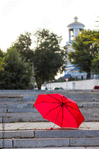 Big red umbrella on gray city streets