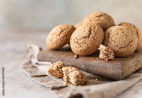 Oatmeal cookies on wooden cutting board, brown concrete background. Healthy snack or dessert.