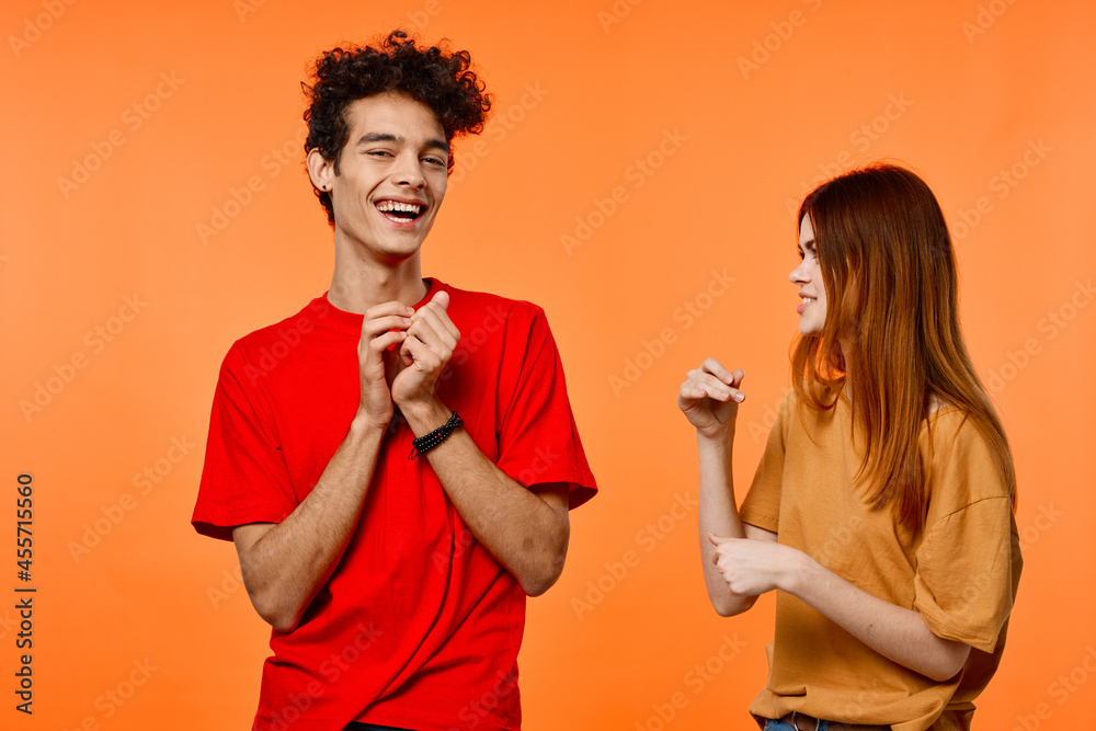 young couple fun friendship communication orange background fashion