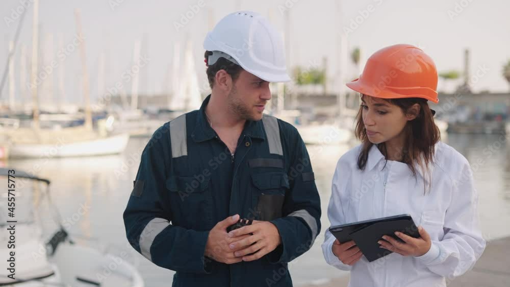 Female marina surveyor inspector talking with seafarer Female marina surveyor inspector talking with seafarer