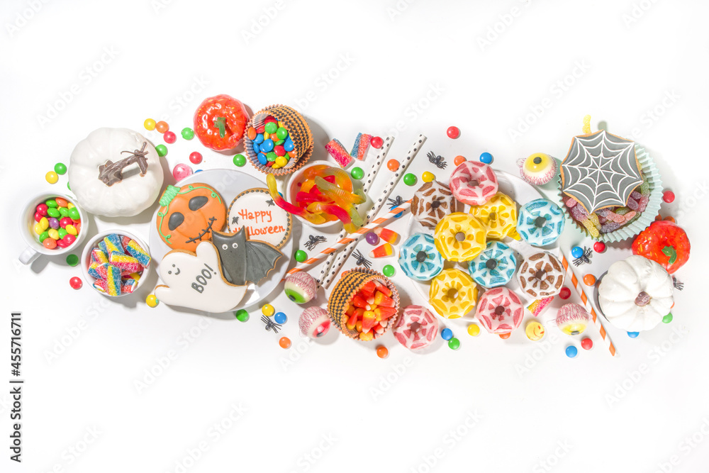 Set of various classic Halloween treats on white background. Selection assortment traditional cookies, gingerbread, candy, sweets and decor pumpkins. Trick or treat concept, top view copy space